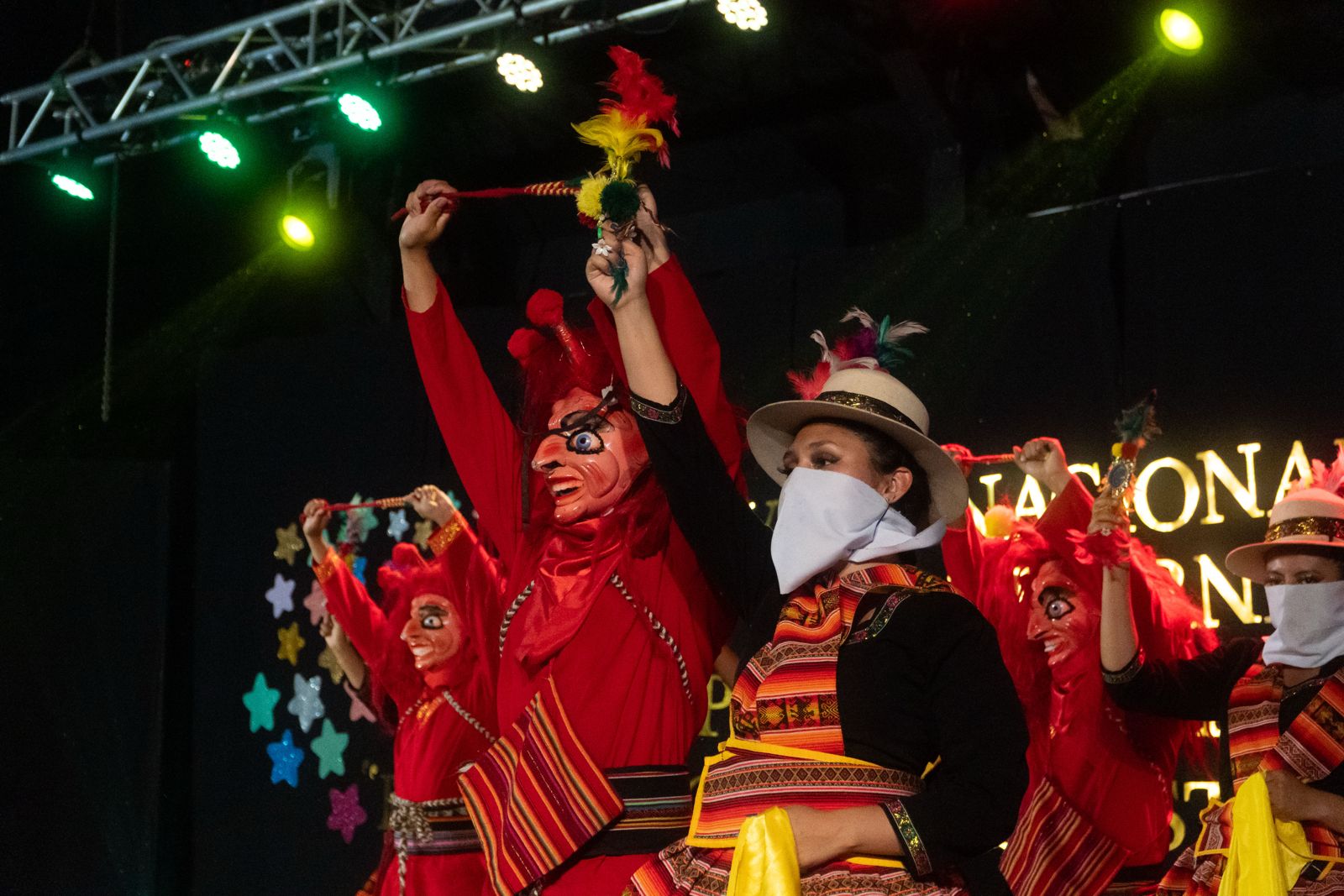 Danza tradicional con trajes rojos y máscaras en el escenario