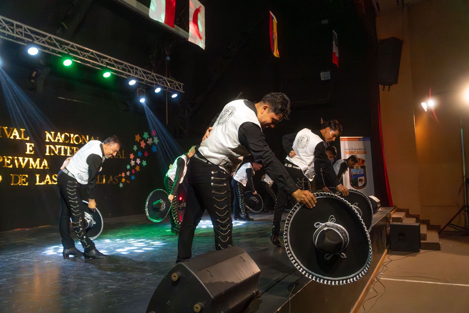 Bailarines con trajes negros tradicionales en escena