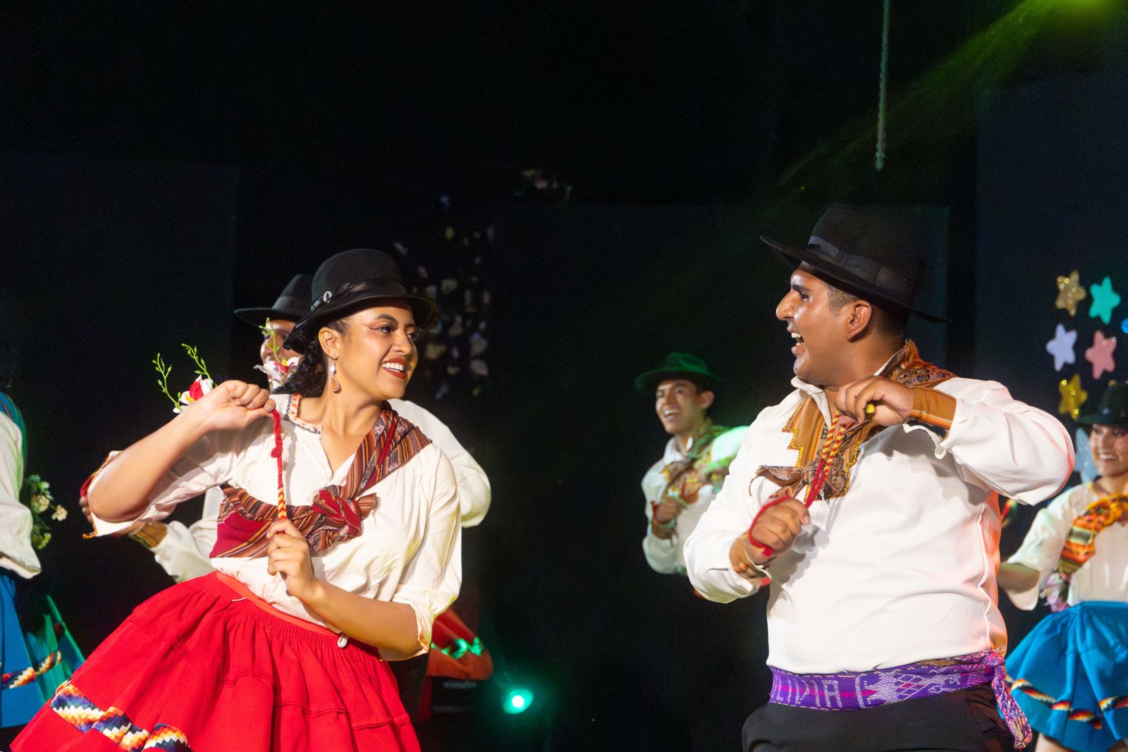 Pareja con trajes tradicionales rojos en el escenario