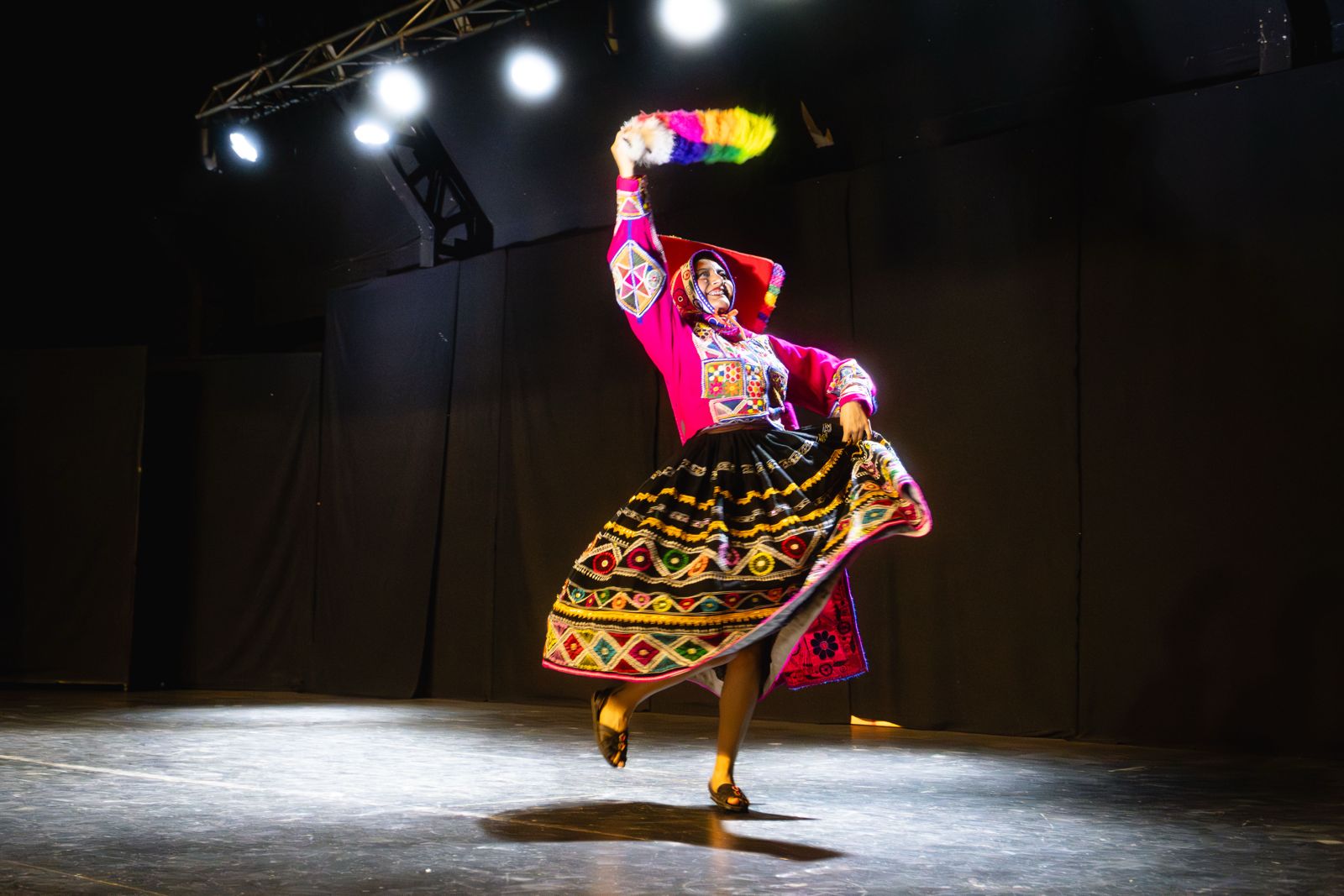 Bailarina con vestido andino colorido en plena danza