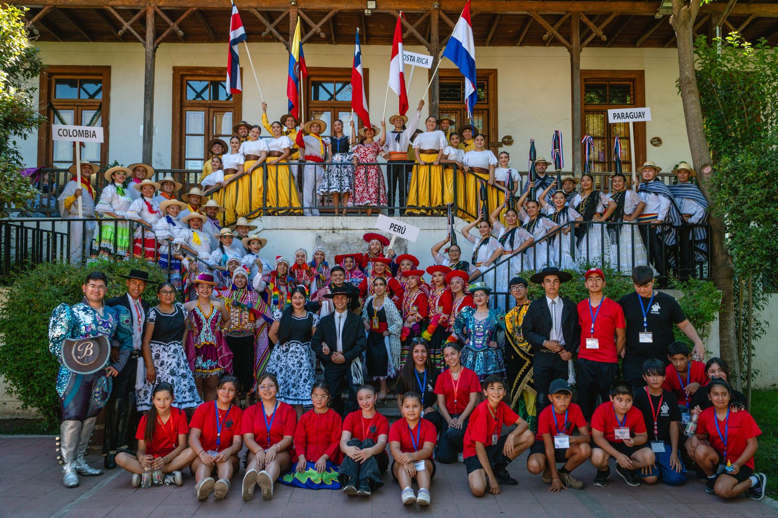 Delegaciones internacionales del festival posando con las banderas de sus países
